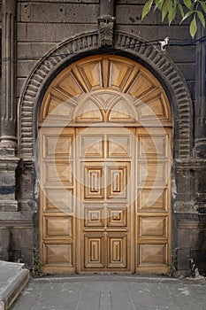 Old classical stone house with rustic, brown, carved, vintage wooden door. Door textures and backgound.