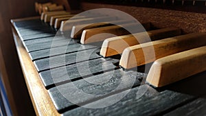 Old classy wooden musical instrument keyboard closeup, pipe organ manual, keys macro, dramatic high contrast lighting