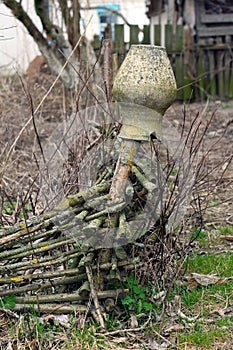 Old clay broken pitcher hanging on a wicker fence