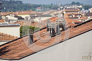 Old clay chimney pots and brick chimney stacks on old tiled roof complete with TV aerials in England, UK.