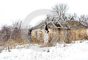 Old clay house in the Ukrainian village. Ruined clay house in the snow.