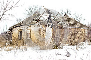 Old clay house in the Ukrainian village. Ruined clay house in the snow.