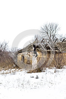 Old clay house in the Ukrainian village. Ruined clay house in the snow.