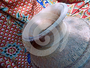 Old clay jar on red and green Batik fabric background
