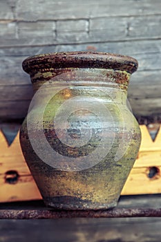 Old clay jug on wooden