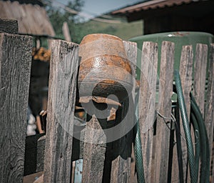 An old clay pot on the wooden fence