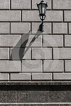 Old stone block wall with vintage street lantern