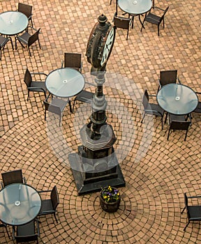 Old clock in a cafe square with pavement
