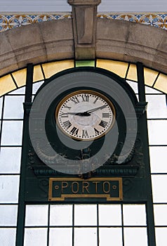 Old clock in central railway station in Porto, Portugal. Hall of famous Sao Bento train station. Interior of ancient station.