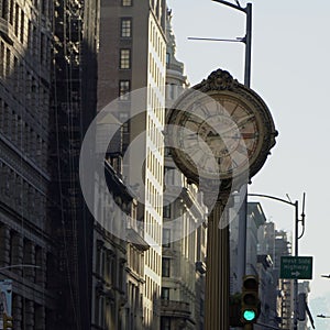 an old clock on the corner of a street in a city photo