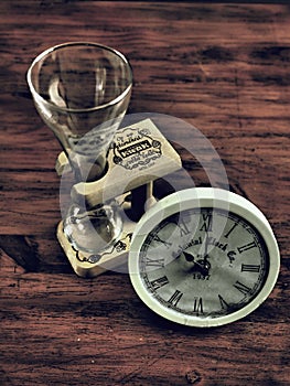 Old clock with empty beer mug on mahogany table