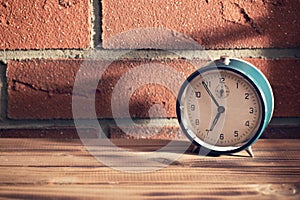 Old clock in front of a brick wall