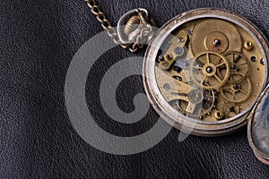 Old clock mechanism on black leather background