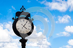 Old clock over the blue sky and white clouds