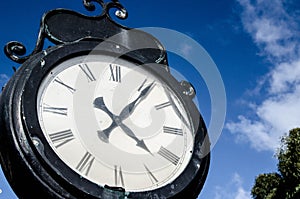 Old clock over the blue sky and white clouds