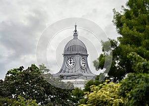 Old clock tower with dome on top clock face showing 12:15 quarter past twelve o'clock.