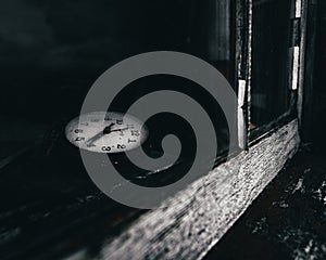 an old clock with it's face up on the windowsill