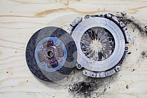 Old Clutch disc and Clutch cover on top of a wooden plate.