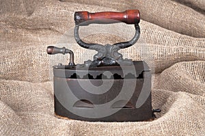 The old coal iron on fabric background