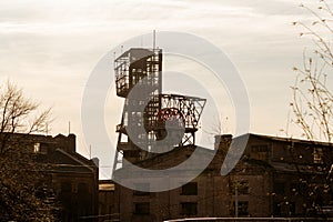 Old coal mine shaft tower with ruined buildings