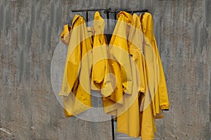 Raincoats hanging on an old rusty rack photo
