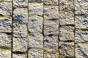 Old cobblestone background with grass, Texture of stone paving stones