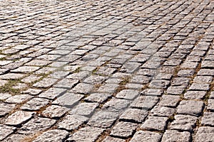 Old cobblestone pavement. Street with granite cobblestoned pavement