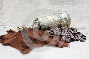 Old coffee grinder with coffee beans and powder