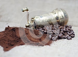 Old coffee grinder with coffee beans and powder