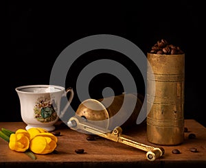 Old coffee grinder with cup and coffee beans