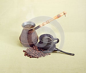 Old coffee pot, black ceramic cup with coffee, coffee beans