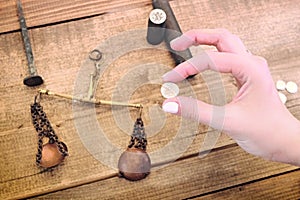 An old coin in a woman`s hand. Set to create retro silver money by minting. Scales and other tools for making coins photo