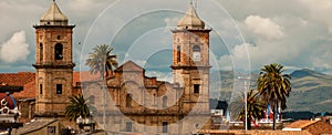 Old colonial stone church with roofs and palm tree