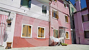 Old colored residential houses on Burano island, hot summer day in Italy, Venice