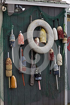 Old colorful buoys hanging from fishing shack wall
