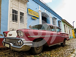 Old colorful Cuban car on cobblestone street