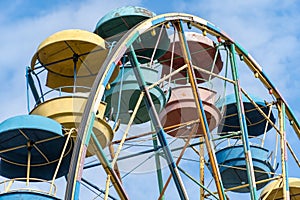 Old colorful ferris wheel in amusement park. Multicolour soviet carousel.