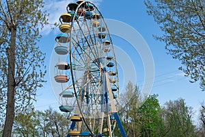 Old colorful ferris wheel in amusement park. Multicolour soviet carousel.