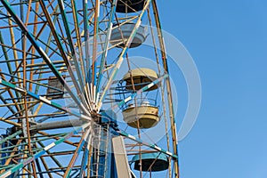 Old colorful ferris wheel in amusement park. Multicolour soviet carousel.