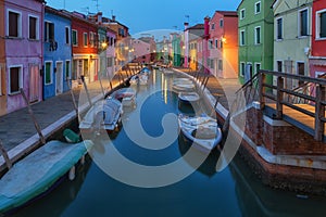 Old colorful houses and boats at night in Burano