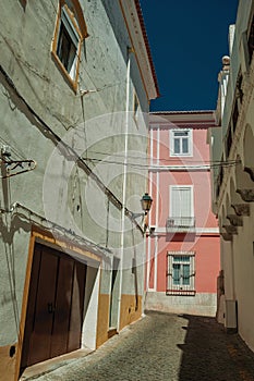 Old colorful houses with rough plaster wall in a deserted alley