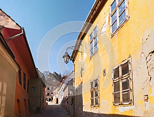 Old colorful houses in Sighisoara citadel on a sunny spring morning. View towards the Church on the Hill