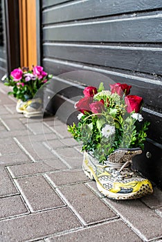 Old colorful sports shoes used as flower pot vase for a wedding decoration