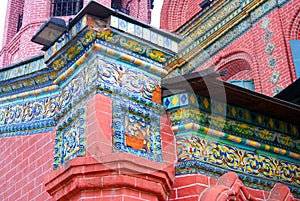 Old colorful tail on the red bricks wall of Epiphany church.