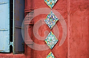 Old colorful tails on the red bricks wall of Epiphany church.