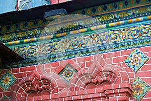 Old colorful tails on the red bricks wall of Epiphany church.