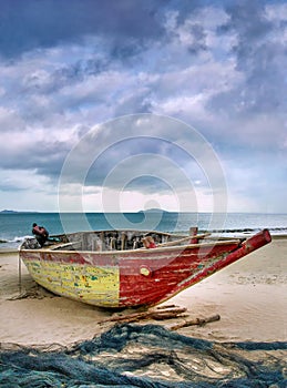 Old colorful wooden fisher boat on an overcast beach