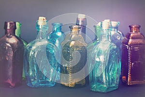 Old colourful bottles against a dark background