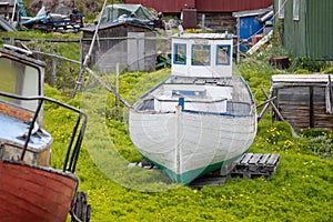 Old colourful red, green and blue fishing boats with peeling paint on land in Sisimiut, Greenland