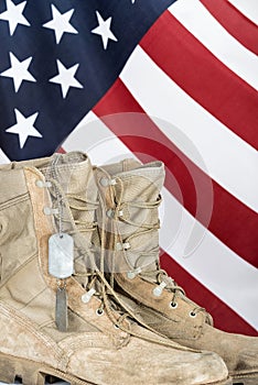 Old combat boots and dog tags with American flag